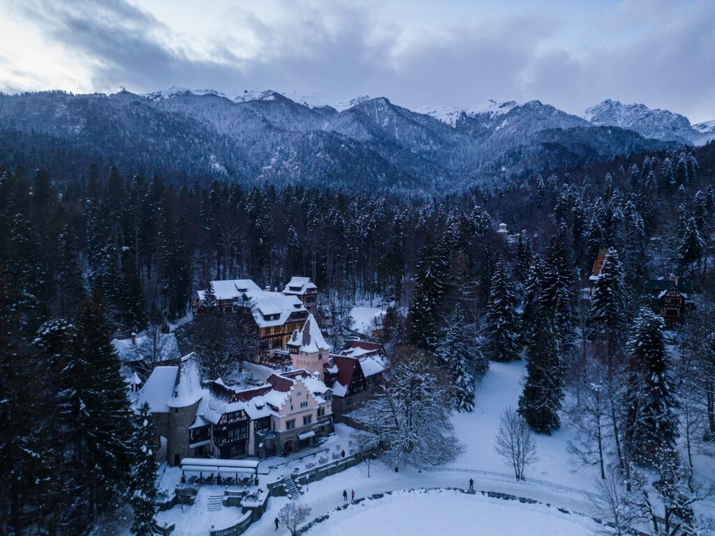 10 Enchanting Destinations You Must Discover in Romania 3 Aerial view of old castle in winter. Sinaia, Romania.