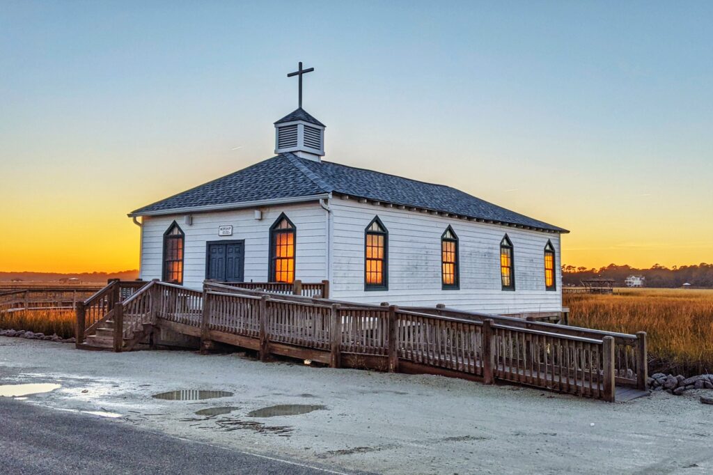 Explore the Charming Wonders: Top 10 Must-Visit Destinations in South Carolina 9 Beautiful scenery of Pawleys island chapel with a sunset background