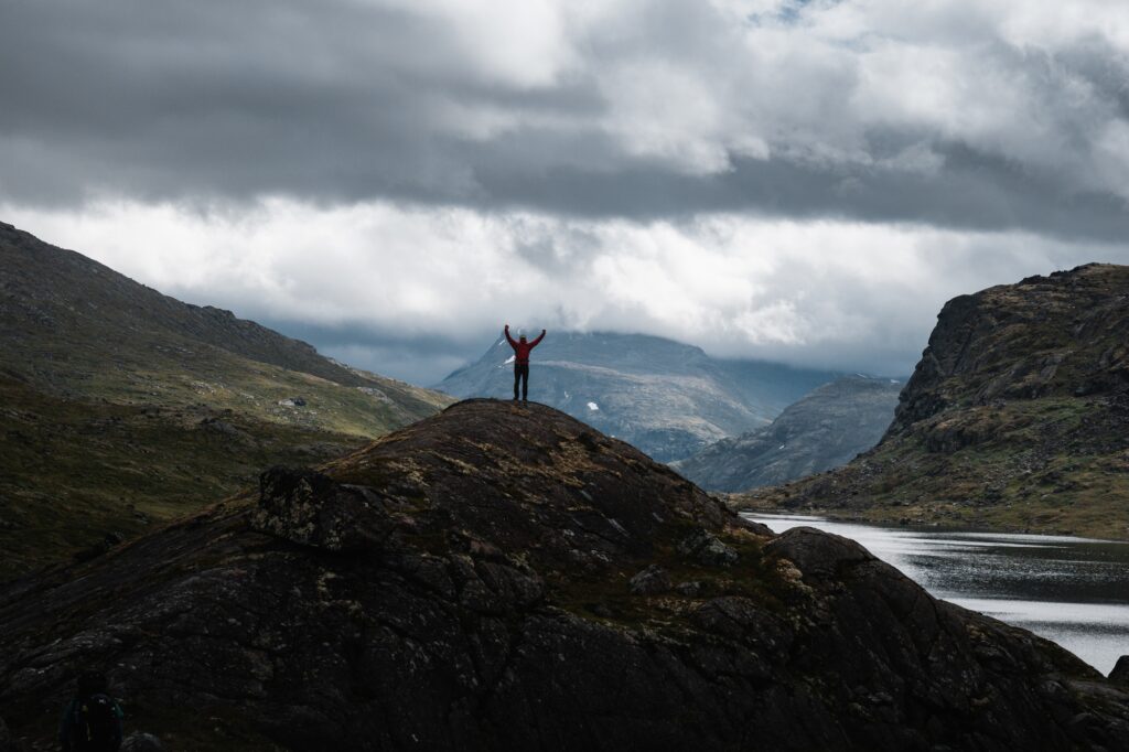 7 Enchanting Reasons to Embark on a Journey to Norway 4 Hiker Celebrating on a Mountain Top with River in Norway