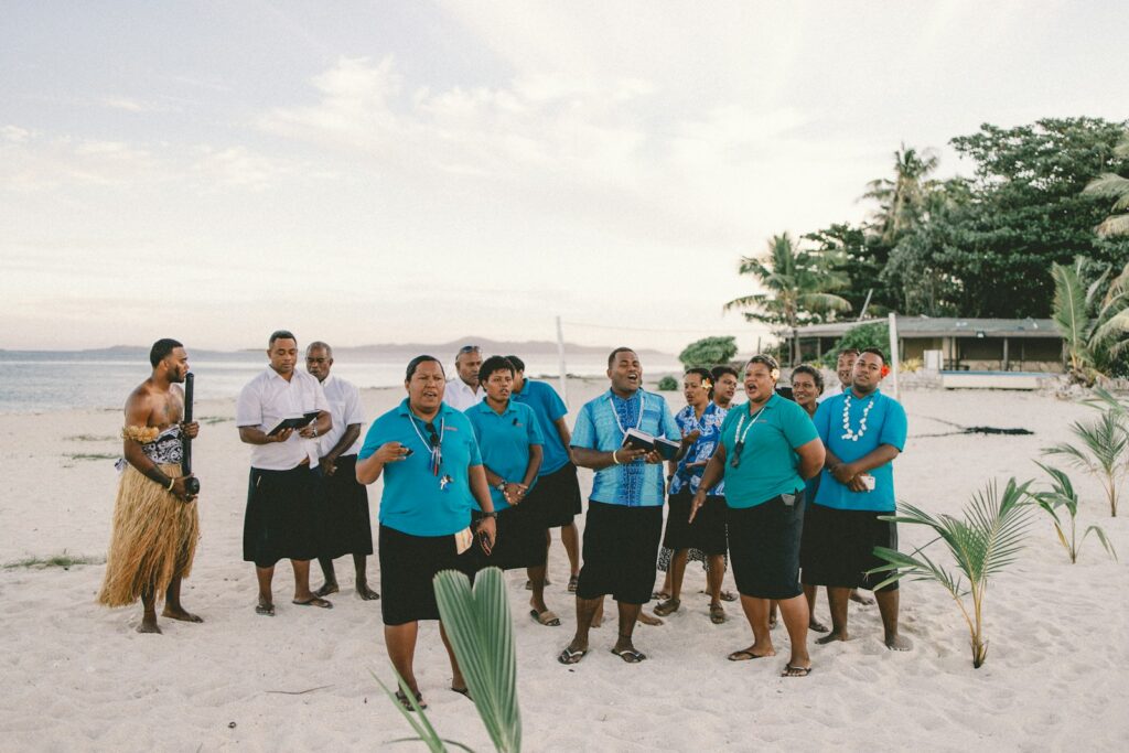 a group of people standing on top of a sandy beach