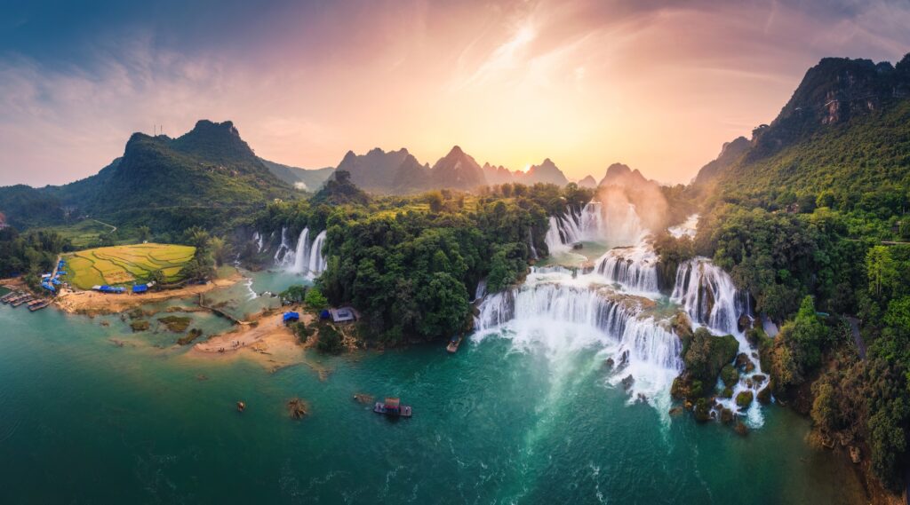 17 Majestic Waterfalls You Simply Can't Miss 8 Majestic Ban Gioc waterfall, Detian Falls flowing in tropical forest during the sunset at Vietnam