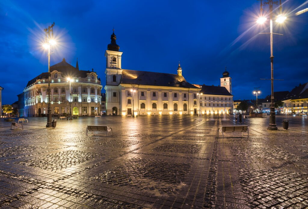 15 Extraordinary Destinations You Can’t Miss in Romania 12 Sibiu City Hall and Baroque Jesuit Church in Piata Mare (Great Square) at night, Transylvania, Roman