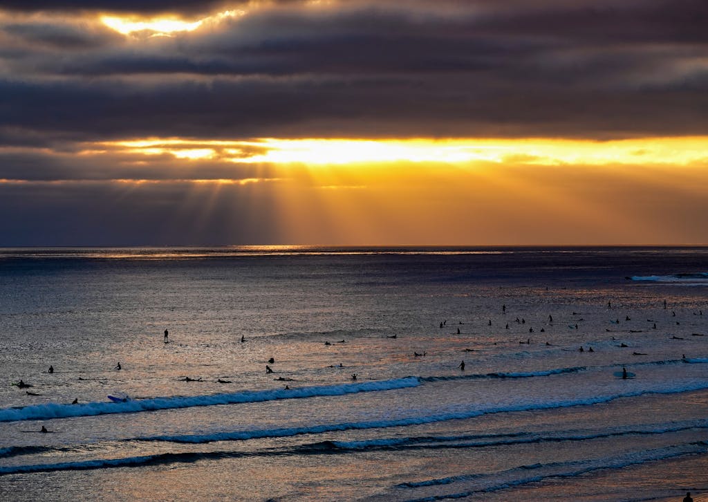 8 Cool Islands in the US You Can Actually Drive To 4 Surfers enjoy the waves under a stunning sunset at South Padre Island, Texas.