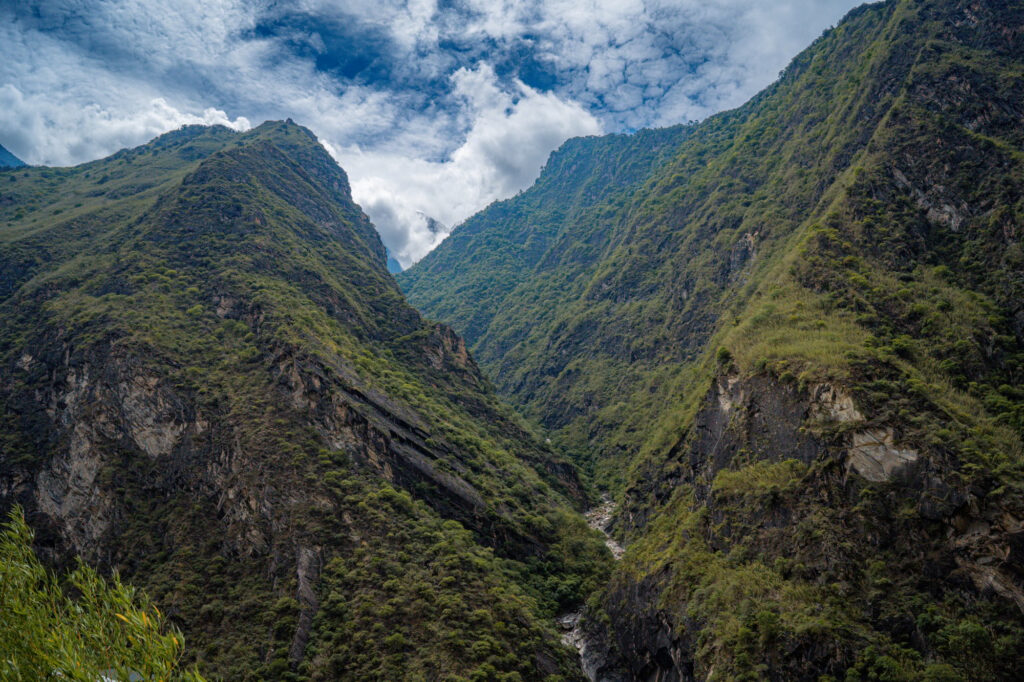 Explore China's Hidden Gems: 14 Must-Visit Destinations for Your Next Adventure 4 View to the steep valley of Tiger Leaping Gorge with meandering Yangtze River below in the summer.