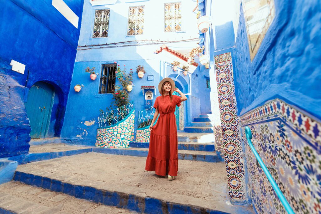 17 Enchanting Destinations in Morocco That You Must Experience 15 Young woman with red dress visiting the blue city Chefchaouen, Marocco