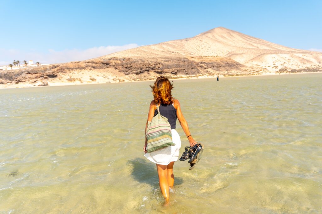 10 Enchanting Beaches in the Canary Islands You Cannot Miss 7 A young tourist walking along the Sotavento beach in the south of Fuerteventura