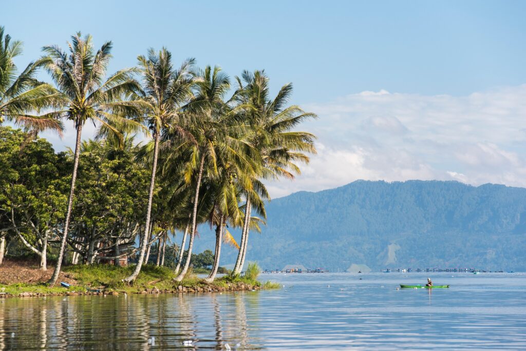 10 Extraordinary Destinations in Indonesia You Can’t Miss 3 Fisherman and palm trees, Lake Toba (Danau Toba), North Sumatra, Indonesia, Asia