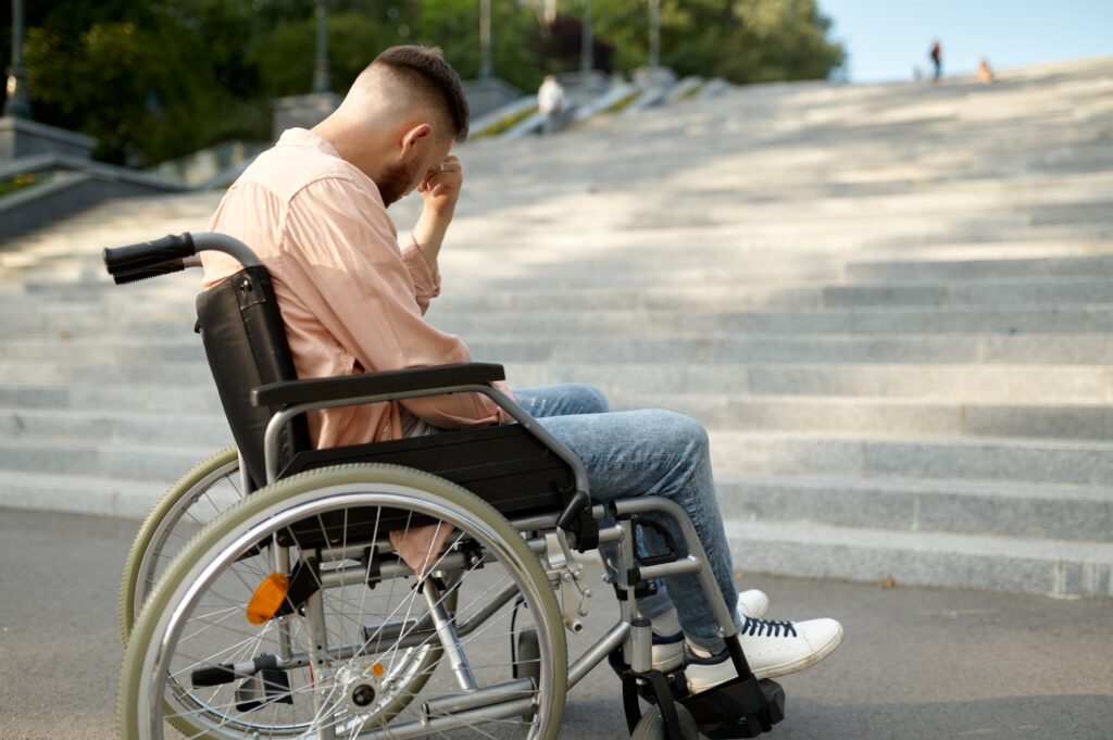 5 Compelling Reasons You Shouldn't Travel Without Insurance 3 Man in wheelchair at the stairs, handicap problem