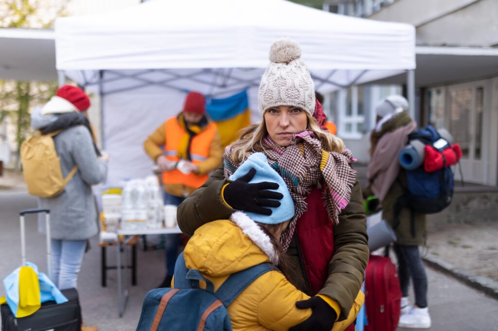 5 Compelling Reasons You Shouldn't Travel Without Insurance 6 Ukrainian refugee mother with child crossing border and looking at camera