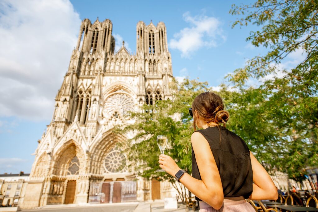 10 Majestic Gothic Cathedrals You Can’t Miss in Europe 8 Woman with a glass of champagne in Reims, France